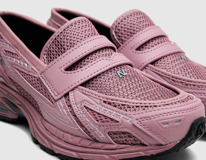 New Balance 1906L. Close-up three-quarter view of rosewood pink mesh upper showing classic leather penny loafer strap, small N logo on toe, and leather overlays. 