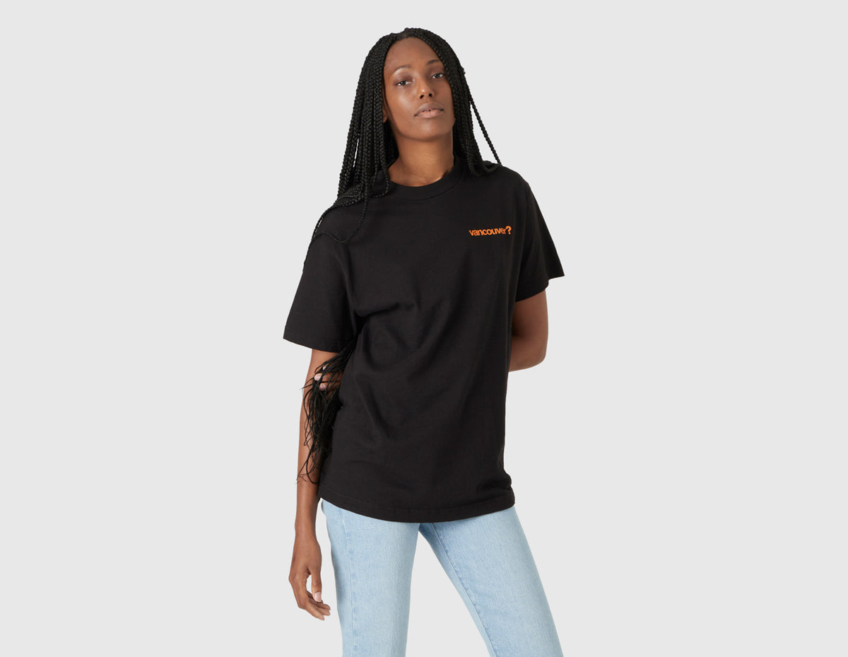 size? Vancouver Logo T-Shirt. Front model view of female model wearing the black shortsleeve t-shirt with orange left chest logo. 