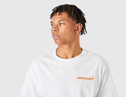 size? Vancouver Logo T-Shirt. Three-quarter model view showing male model looking to the side in the white shortsleeve t-shirt with orange chest logo. 