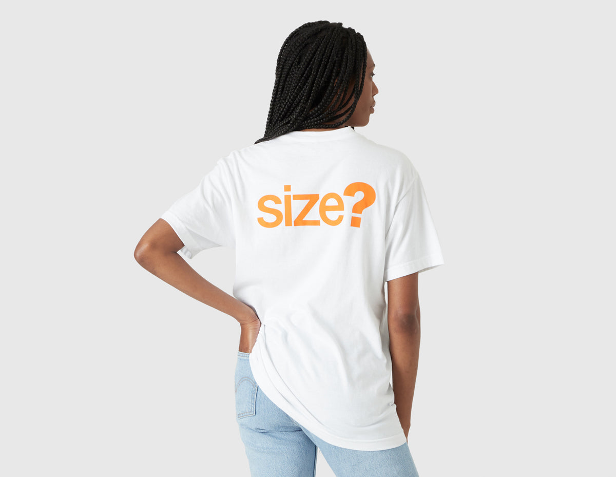 size? Vancouver Logo T-Shirt. Rear model view of female model showing large orange printed "size?" logo graphic across the upper back of the white t-shirt. 