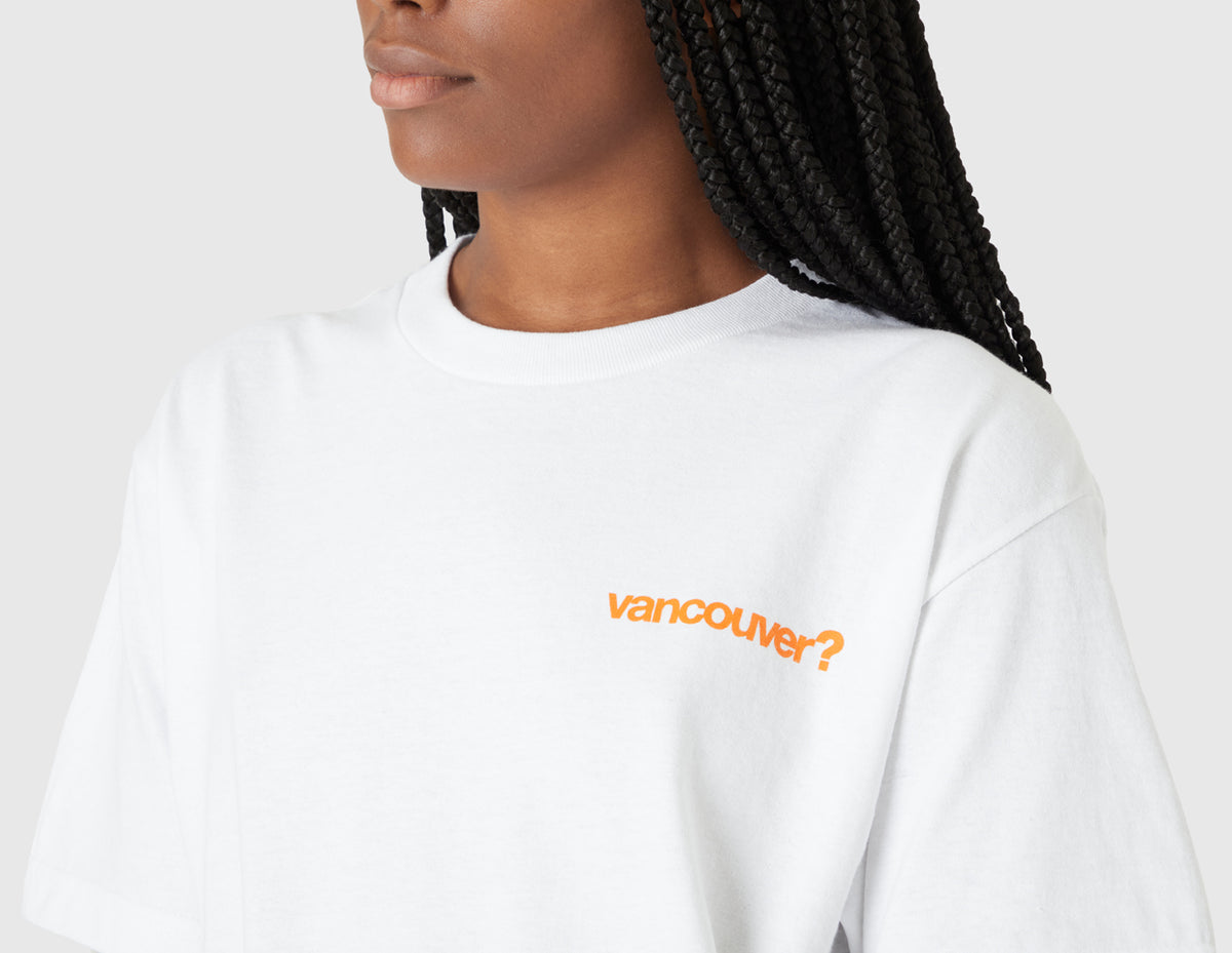 size? Vancouver Logo T-Shirt. Close-up model view of female model highlighting the orange printed "vancouver?" logo on the left chest. 